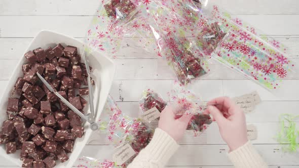 Flat lay. Step by step. Packaging homemade macadamia fudge into small gift bags. alt