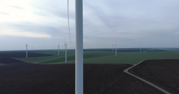 Windmill Farm on Field, Dolly in Aerial View, Passing Wind Turbine alt
