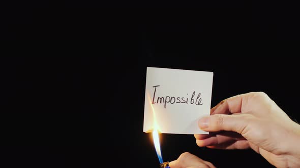 Man Burns a Paper with the Inscription Impossible alt