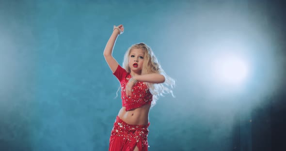 Beautiful and Cheerful Girl Waving Her Hair and Head in an Oriental Dance alt