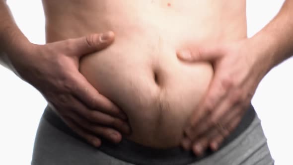Fat Man with a Big Belly Shows His Fat on a White Screen alt