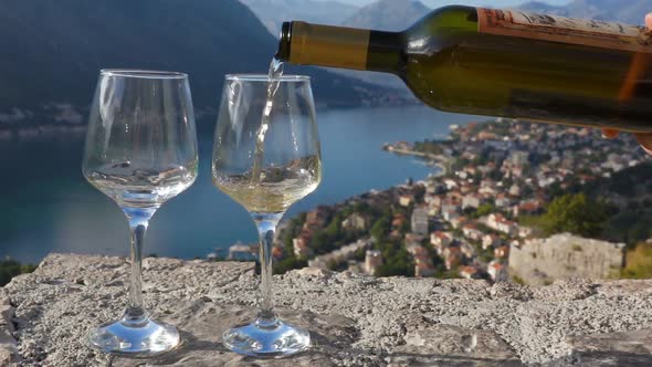 White Wine Is Poured Into a Glass Against the Backdrop of the Bay