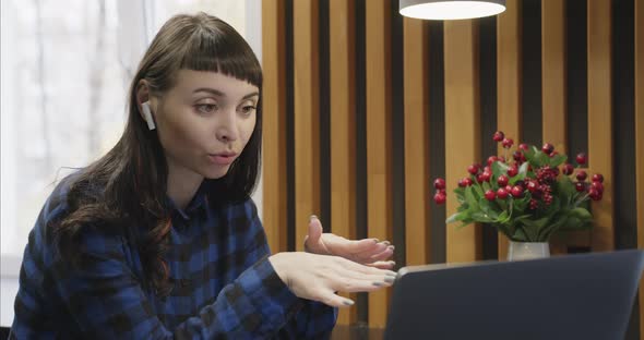 Portrait of a Young Girl in Headphones Talking in Front of a Laptop Screen alt
