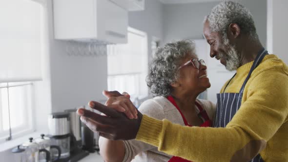 A senior african american couple spending time together at home dancing in the kitchen social distan alt