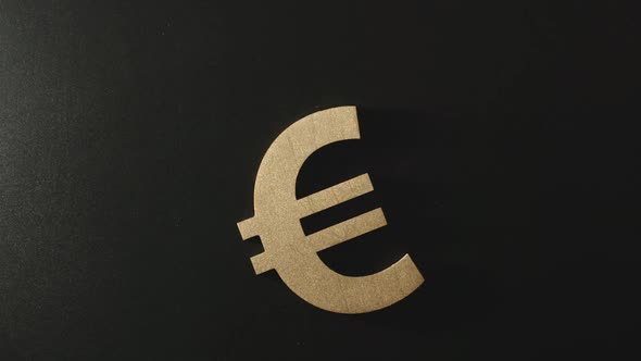 Wooden euro symbol falls in darkness