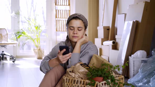 Woman Unpack Box in New Flat on Mowing Day