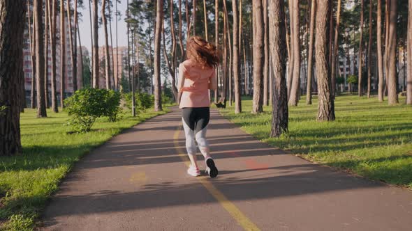 Woman Running at a Leisurely Pace in Summer Park