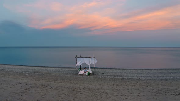 canopy bed on the beach at dawn alt