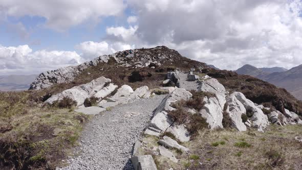 Panoramic Walking Along Stone Path in Irish Mountain in a Sunny Day with Clouds in Summer