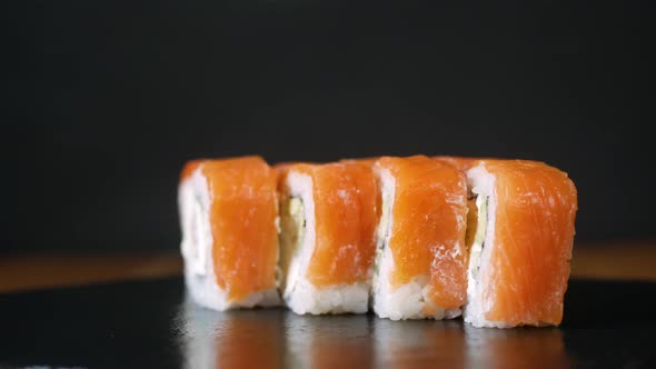 Sushi Rolls Spin in a Circle on Black Plate