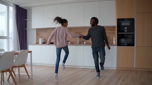 Active Happy African American Family Jumping Dancing and Having Fun at Home alt