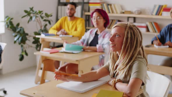 Female Student Asking Senior Professor during College Lecture alt