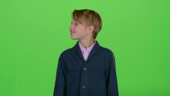 Teenager Looks Around and Then Shows a Credit Card on a Green Screen alt