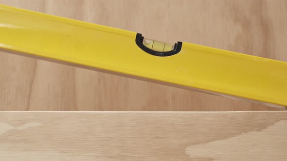 Bubble Level Being Placed on Top of Finished Hardwood Project