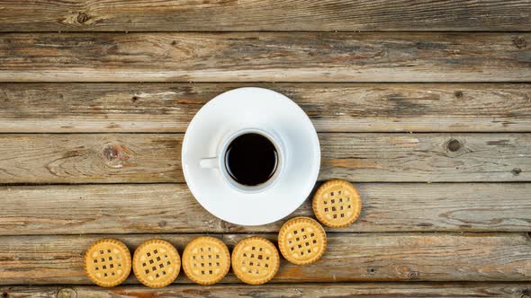 Vanilla White Cookies And A Cup Of Coffee Move On A Wooden Surface.