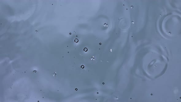 Super Slow Motion Top Shot of Water Drops Falling Into Water Surface at 1000Fps alt