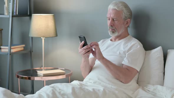 Smartphone Use By Old Man in Bed alt