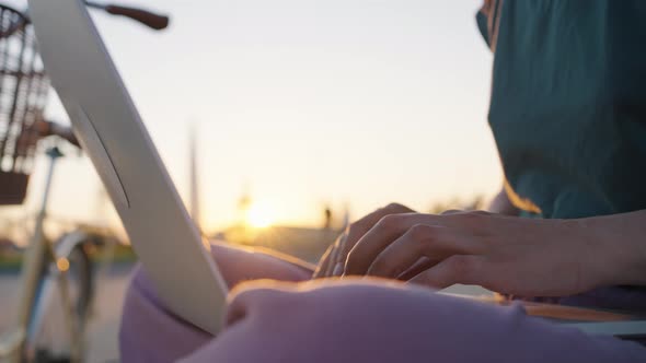 Businesswoman Freelancer Hands Typing on Laptop Keyboard at Sunset in City Park Closeup alt