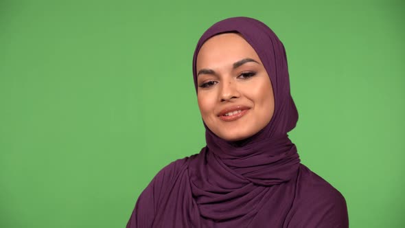 A Young Beautiful Muslim Woman Talks to the Camera with a Smile  Closeup  Green Screen Background