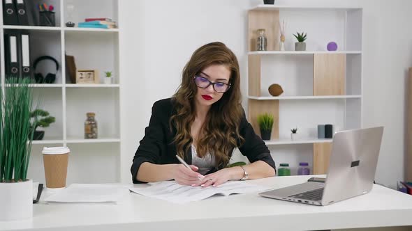 Businesswoman in Glasses Sitting at Her Workplace in Contemporary Office  alt