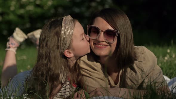 Summer Portrait of Mom and Preschool Daughter Lying on the Grass in the Park alt