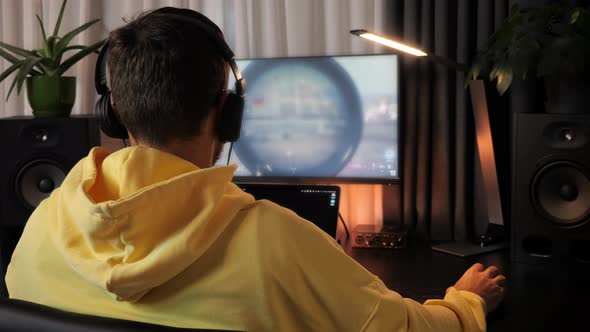 Professional gamer in headphones having live stream playing online video game. alt