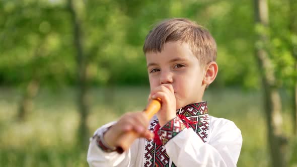 Adorable Boy Playing on Woodwind Wooden Flute  Ukrainian Sopilka alt