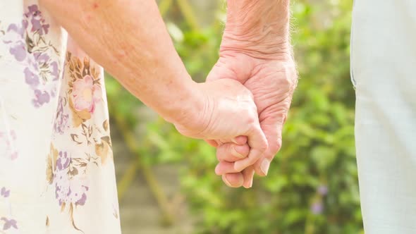 Elderly couple holding hands