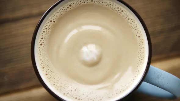 Drop of Milk Falls Into Full Cup of Coffee alt