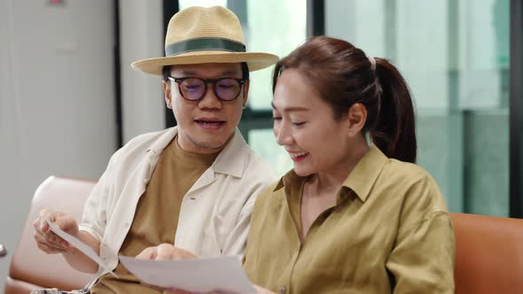 4K Asian couple waiting for boarding time in airport terminal.