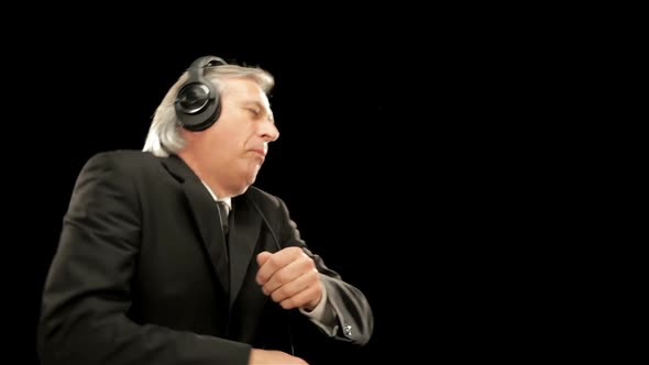 Middle Age Elegant Businessman is Listening Music and Dancing Isolated on Black
