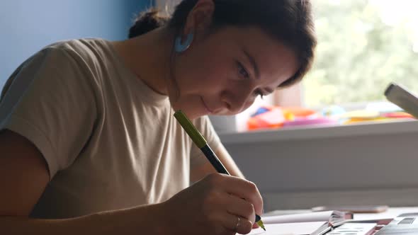 decorator sits at desk and develops sketch fulfilling order alt