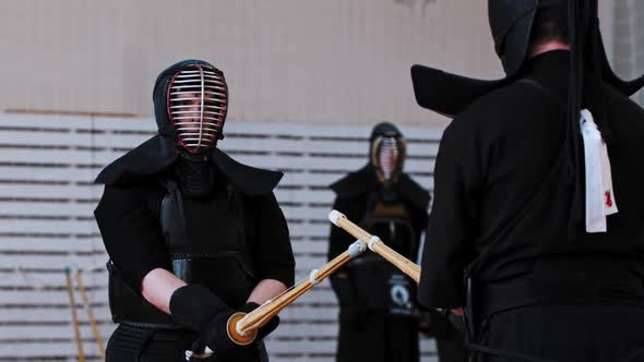 Kendo Tournament in the Gym  Two Men in Black Costumes About to Start a Duel on Bamboo Sticks alt