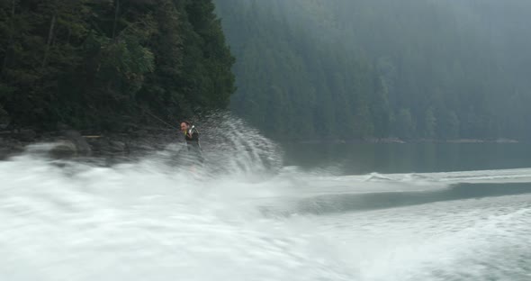 Front view of caucasian young man doing tricks on wakeboard in the city river 4k alt