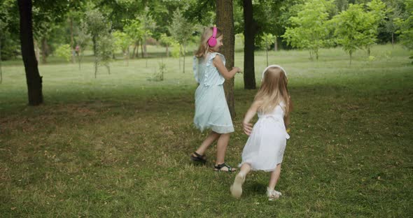 Happy Children Dance and Listen to Music in the Park the Sisters Rotate Day Mode alt