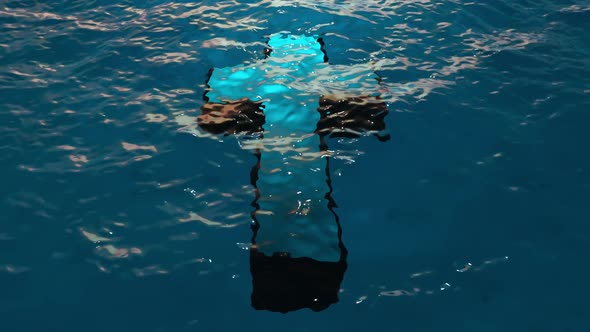 Large Christian religious cross underwater under the sea.