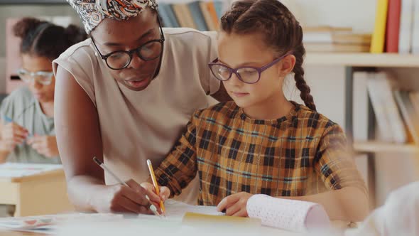 Positive Afro-American Teacher and Caucasian Girl Posing for Camera at Lesson alt