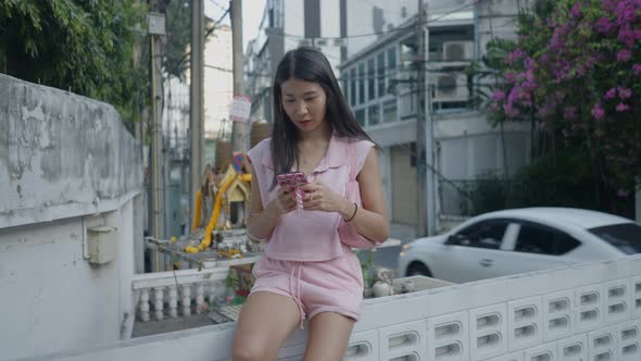Cinematic View of a Lady Sitting on the Border Wall and a Delivery Boy Passed By alt