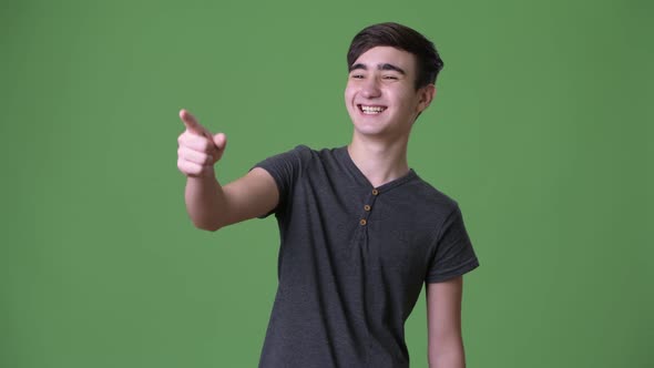 Young Handsome Iranian Teenage Boy Against Green Background alt