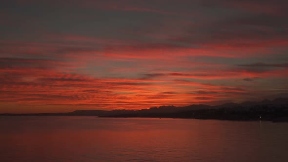 Clouds Over the Mountains and the Sea Lit By the Sun At Sunset alt