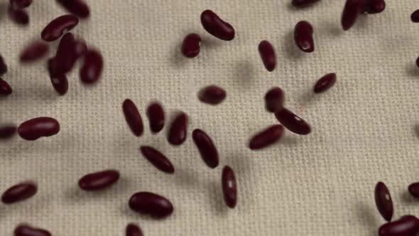 Red beans  on white burlap, slow motion