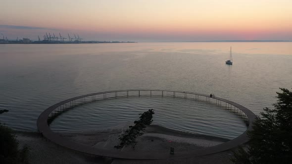 Majestic Scenic View of Infinite Bridge Surrounded By Ocean Waters and Sunset alt