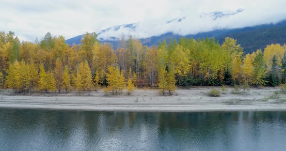 Autumn forest and mountain ranges along the lake alt