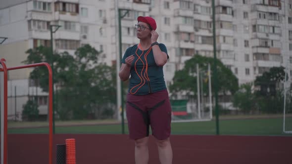 Sports Theme Music in Headphones Overweight Cardio Workout and Weight Loss Goal alt