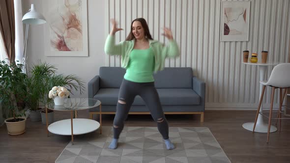 Girl dancing in the living room. Recording videostream video for social media at home.