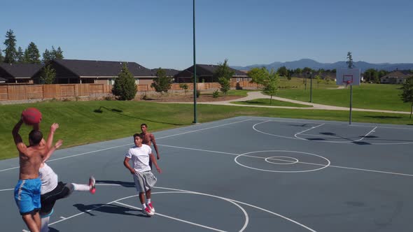 Friends playing basketball at park, high angle shot