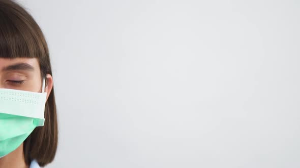 Half Woman Face in Disposable Sterile Mask Looking To Camera and Blinking alt