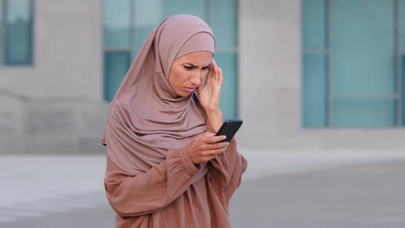 Muslim Islamic Girl Woman in Hijab Stands on Street Outdoors City Uses Mobile Phone Looks at alt