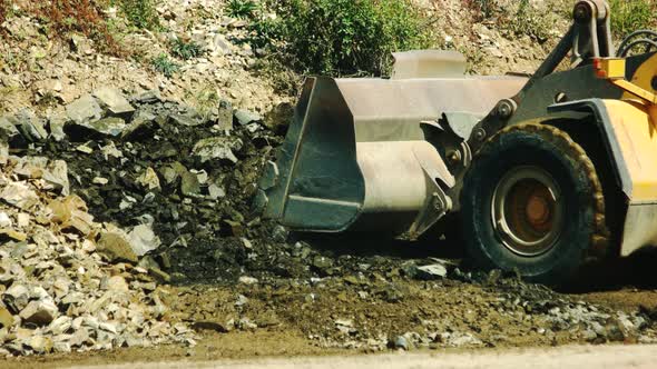 Excavator Loading Granite Stones in the Quarry alt