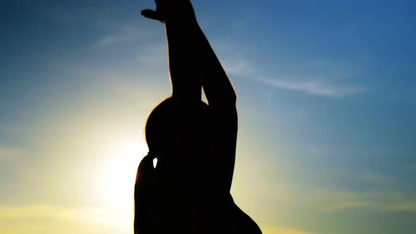 Woman performing yoga on the beach alt
